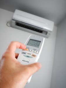hand turning on ductless air handler with remote